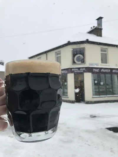 Dark beer pint in snowy weather outside pub