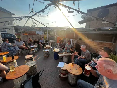 Outdoor area with customers at barrel tables