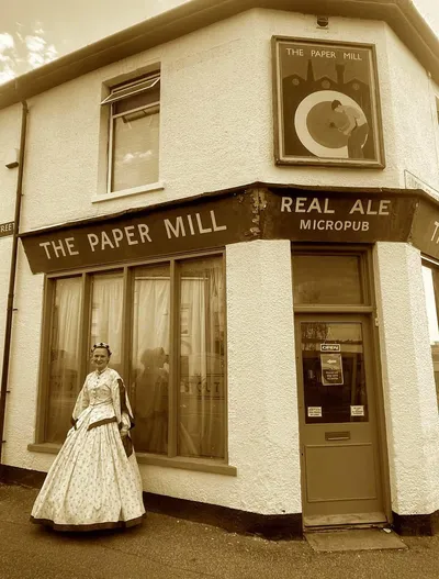 Victorian woman outside pub in sepia