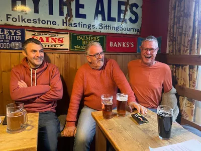 Three men laughing at pub table